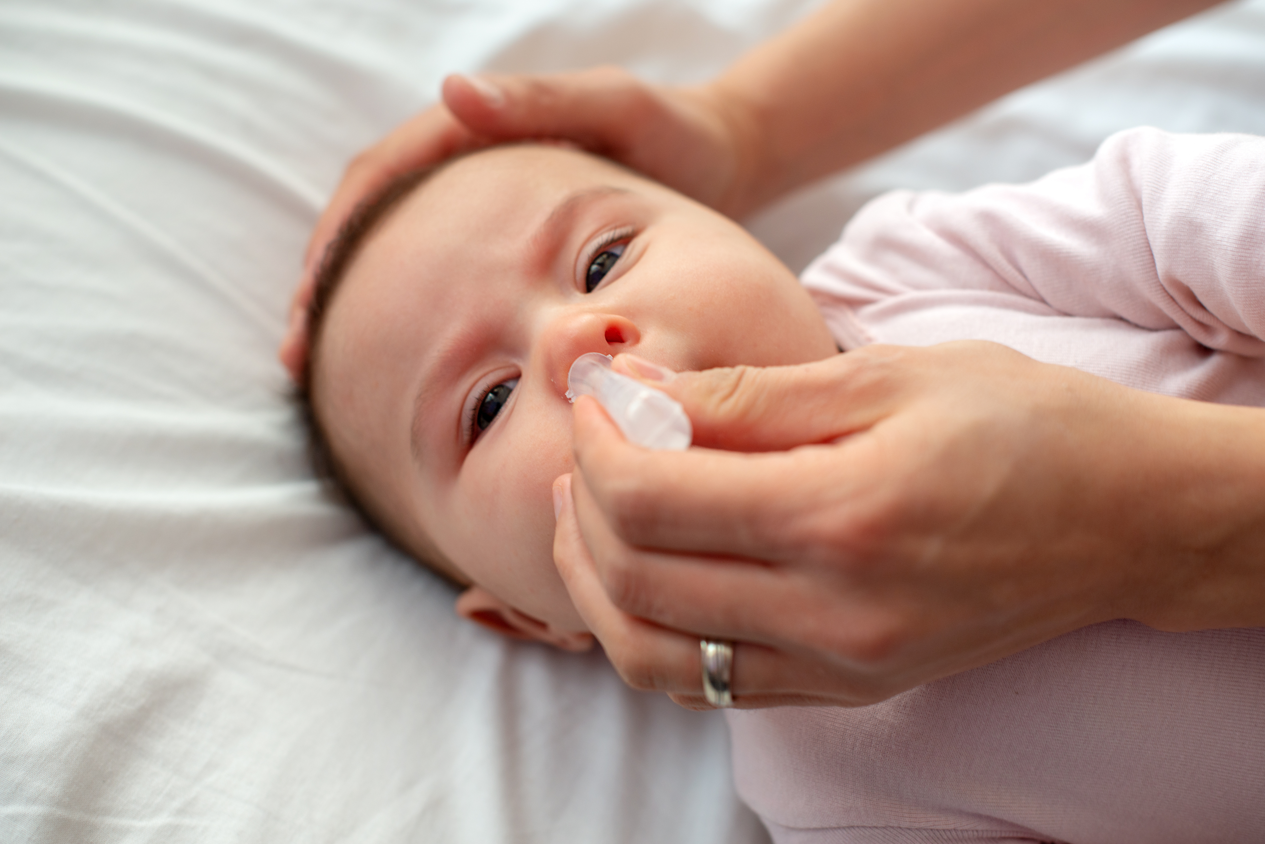Nase von RSV erkranktem Baby mit Kochsalzlösung spülen